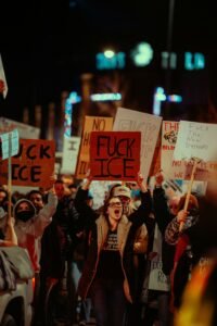 Protesters hold anti-ICE signs during a public demonstration.
