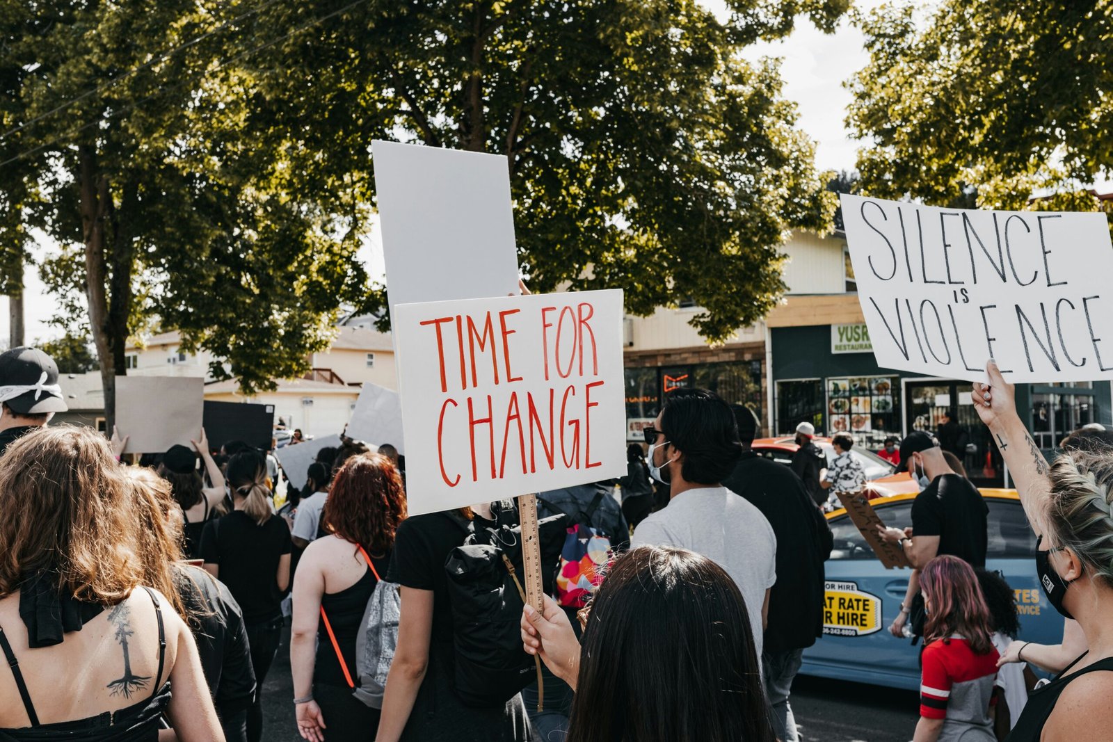 Protesters hold signs during a public demonstration about change and silence.