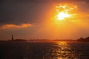 Sunset heat haze over New York Harbor during a major U.S. heat wave.